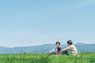 公園でピクニックする日本人家族（コピースペース）
