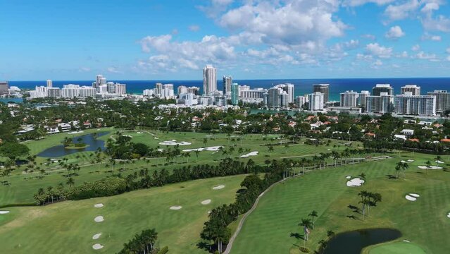 View from drone on spectacular La Gorce Club with stunning high-rise residential buildings along oceanfront and private golf club. Magnificent combination of city and nature