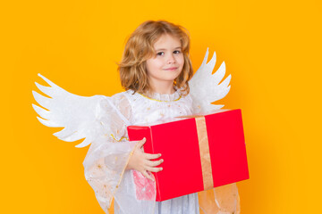 Cute blonde kid angel with gift box present. Beautiful little angel. Isolated studio shot. Cute...