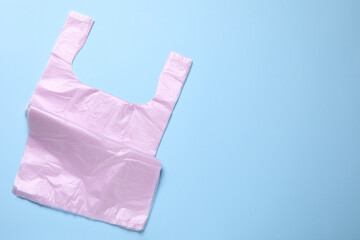 Pack of plastic bags on light blue background, top view. Space for text