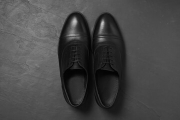 Pair of leather men shoes on grey surface, top view