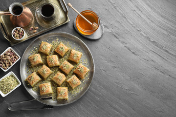 Delicious fresh baklava with chopped nuts served on grey table, flat lay and space for text....