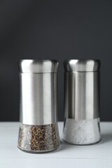 Salt and pepper shakers on white table, closeup