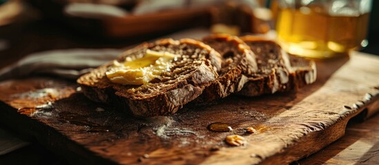 Close-up view of a wooden cutting board with a partially buttered slice of rye bread.