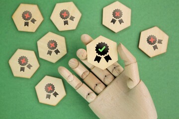 wooden hand and hexagon with certified selected icon. concept of Quality Control Assurance,...
