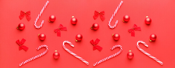 Beautiful Christmas balls with candy canes and bows on color background