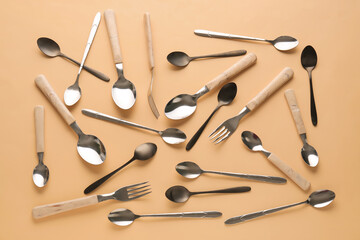 Silver and black cutlery on beige background