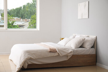 Fototapeta na wymiar Interior of light bedroom with large double bed and white pillows