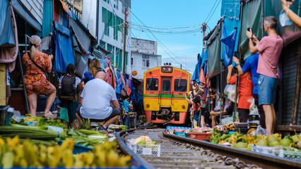 Maeklong Railway Market Thailand, tourist taking photos with mobile of the Fresh Market on the...