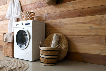 Laundry room interior with washing machine and wicker baskets