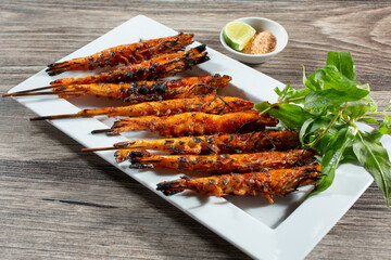 A view of a platter of grilled shrimp on skewers.