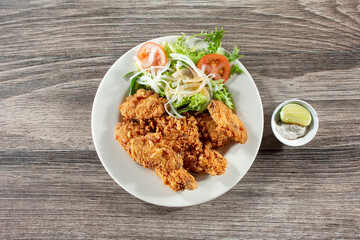 A top down view of a plate of deep fried chicken wings.