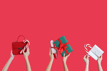 Many hands with Christmas gift, shoe and bags on red background