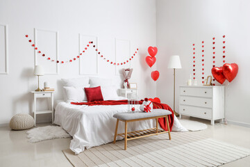 Interior of light bedroom decorated for Valentine's Day with hearts and balloons
