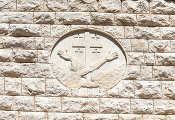 The Vatican coat of arms is carved in stone on the wall of the Church of the Annunciation in the...