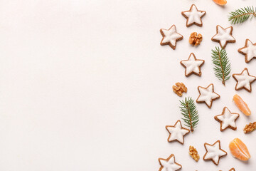 Fototapeta na wymiar Composition with delicious stars shaped Christmas cookies, mandarin, walnuts and fir tree branches on light background