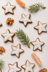 Composition with delicious stars shaped Christmas cookies, mandarin, walnuts and fir tree branches on light background