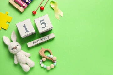 Date of Childhood cancer awareness day with toys and golden ribbon on yellow background