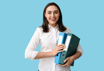 Young businesswoman with document folders on blue background