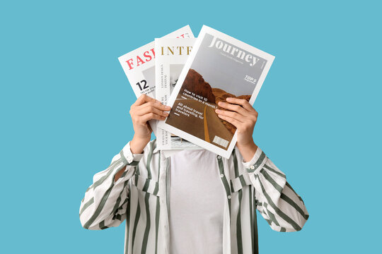 Young woman with magazines on blue background