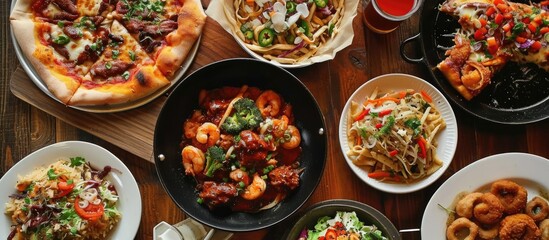 Assorted junk food dishes, pizza and wok, viewed from above.