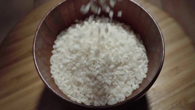 Rice is poured into a wooden cup, top view. Chinese, Thai, Japanese, Indian, as well as Arabic, Australian diet.