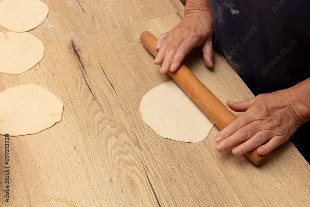 Sticker A woman rolls out dough with a rolling pin