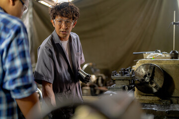 Men are inspecting steel parts for machine installation. team of teacher and student are learning to use heavy machines in steel factory. workers cooperate while doing quality control of manufactured.