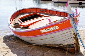 barque small boat on the edge of the Mediterranean sea at the port in Saint Tropez with text name of village city