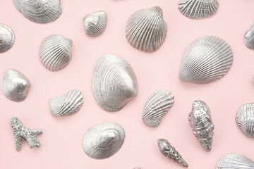 Silver sea shells arrange on pink.