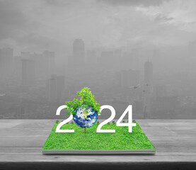 2024 white text with planet and tree on green grass on open book on table over pollution city, Happy new year 2024 ecological cover, Save the earth concept, Elements of this image furnished by NASA