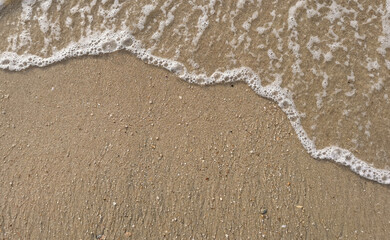White bubble of Sea wave on fine sand at the beach