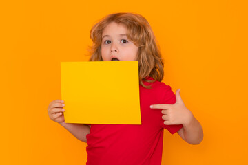 Fototapeta na wymiar Child showing blank banner on yellow isolated background . Advertising billboard, placard. Child hold empty color blank sheet of paper, copy spase. Poster for your text information. Amazed emotions of