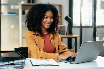 Young woman typing on tablet and laptop while sitting at the working in office