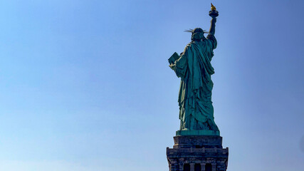 The famous Statue of Liberty of the Big Apple and Manhattan seen from the back, a monument known as...