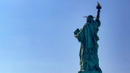 Photograph of the famous statue of liberty of the Big Apple and Manhattan seen from the back,...