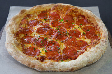 hot pepperoni pizza with green basil close-up