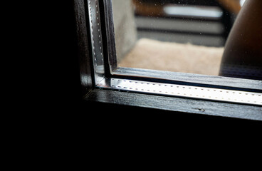 Insulated glass on brown painted wooden window close up shot.