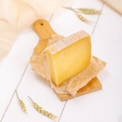 Maasdam cheese on craft paper on a light background