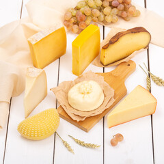 Assorted Italian cheeses on a cutting board on a light background