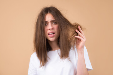 Sad stressed woman with straight brushed hair. Hair tangling problem. Unhappy girl with tangled hair. Damaged hair combing.