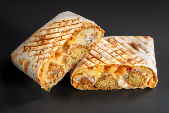 French tacos with Falafel. Cut French Tacos close up on black background.