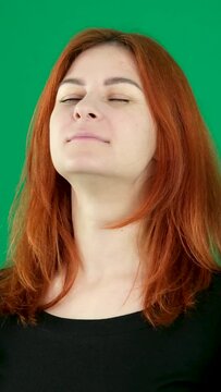 calm yourself slowly exhale and inhale hold your breath close your eyes face of a young red-haired woman on a green background taking a deep breath relaxation relaxation find calm in yourself