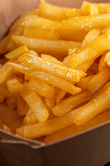 Close up french fries with melted cheddar cheese on top