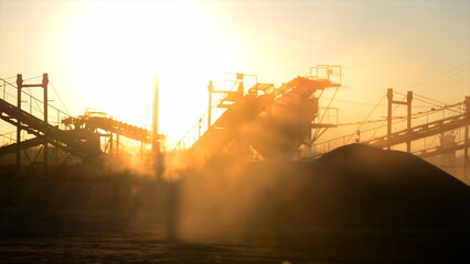 Mining quarry. Crushing plant in granite quarry at sunset dawn. Crusher in quarry. Lot of dust....