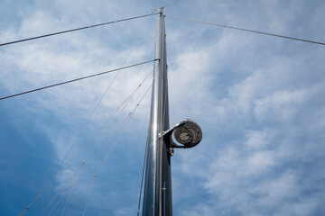 The mast of a sailing yacht with a radar at blue sky background