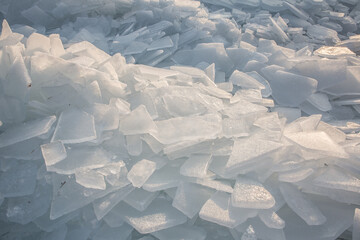 Large pieces of ice near the river bank at sunset