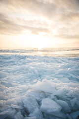 Large pieces of ice near the river bank at sunset