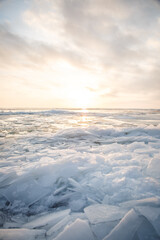 Large pieces of ice near the river bank at sunset