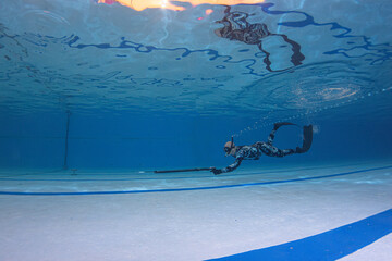 Harpoon practice in a public pool while free diving